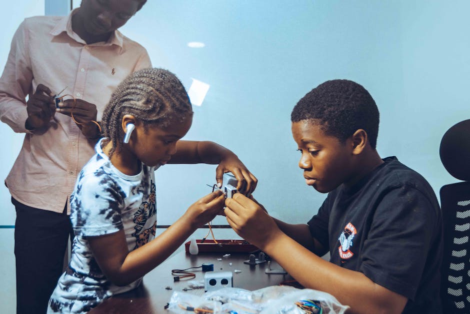 Children collaborating on electronics project in a workshop, fostering STEM education and teamwork.